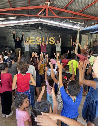 Kids with hands raised at church