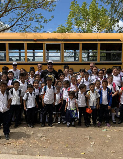 Kids dressed for school in fron tof a school bus